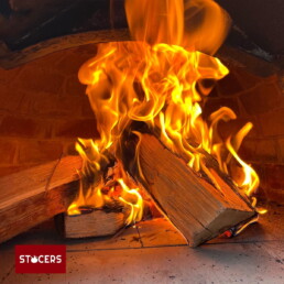 Brandend hout in de pizza oven.
