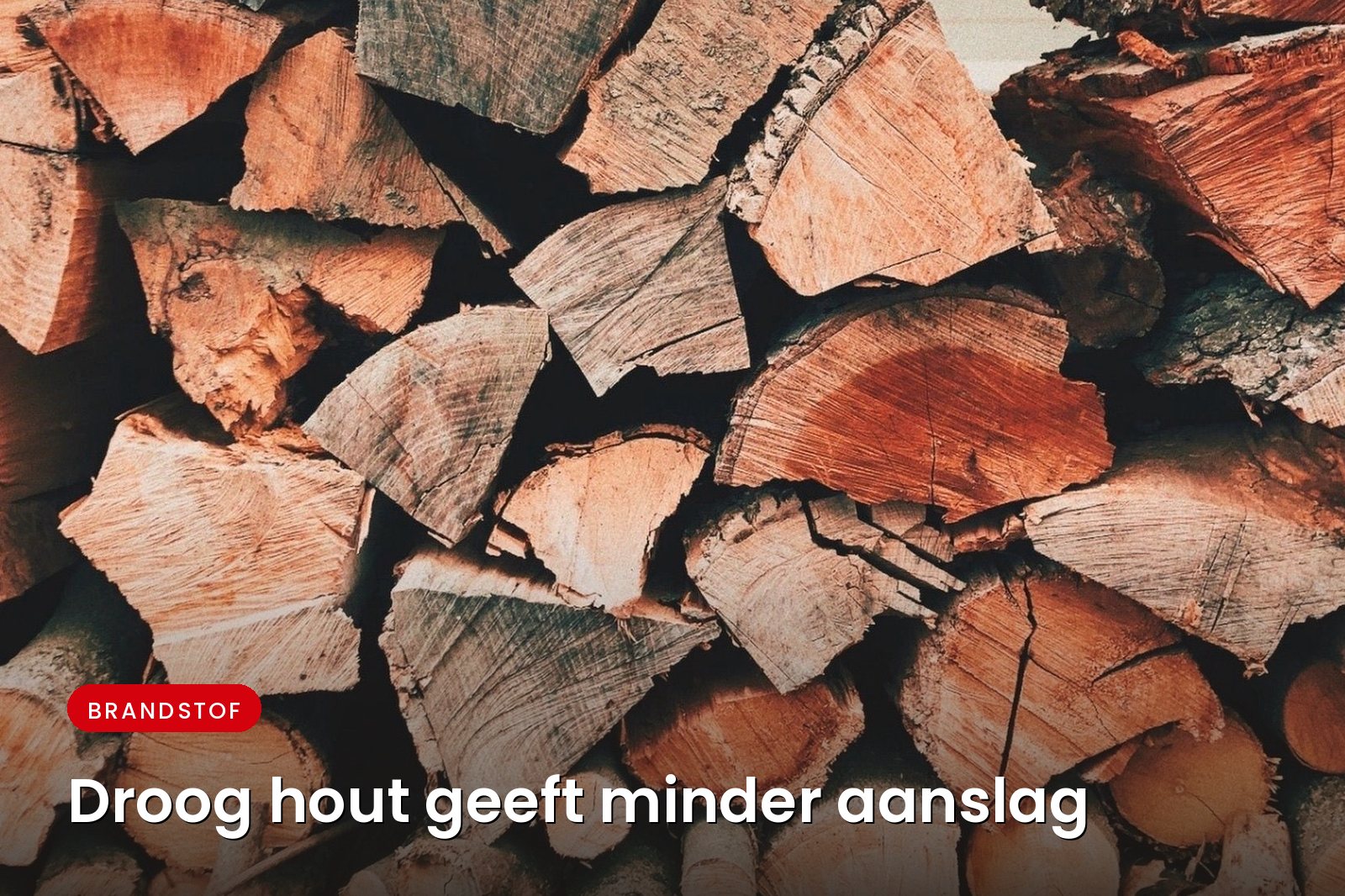 Stapel gekloofd haardhout, droog opgeslagen tegen een wand